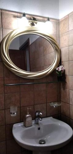 a bathroom with a white sink and a mirror at Poly's Sea Side House in Koropi