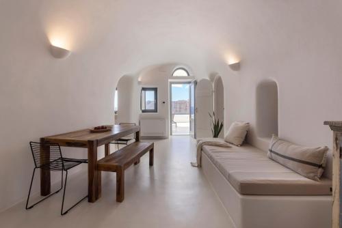 a living room with a couch and a table at Bluedome Cavehouses Santorini in Oia