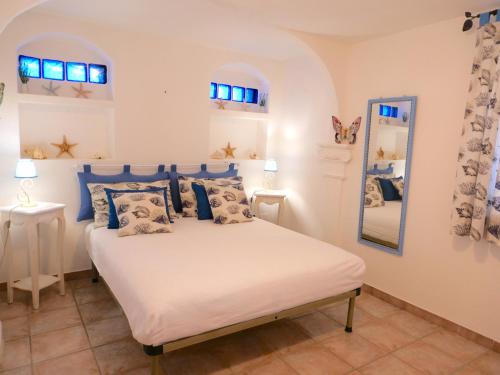 a bedroom with a bed with blue pillows and a mirror at Appartamento in villa panoramica Maladroxia in Maladroscia