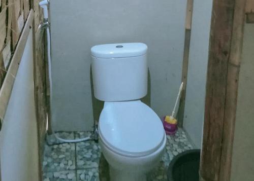 La salle de bains est pourvue de toilettes blanches. dans l'établissement Lembah Cawene Hills Syariah RedPartner, à Gunungpicung