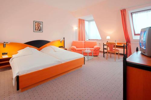 Habitación de hotel con cama y TV en Tryp by Wyndham Kassel City Centre en Kassel