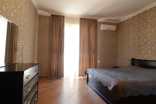 Un dormitorio con una cama y una cómoda y una ventana. en Old Tbilisi Apartment, en Tiflis
