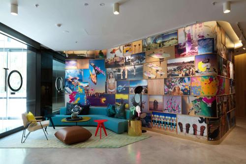 QT Bondi في سيدني: غرفة معيشة مع أريكة زرقاء وجدار من الصور