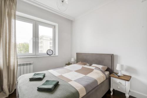 Apartament Muranów في وارسو: غرفة نوم عليها سرير وفوط