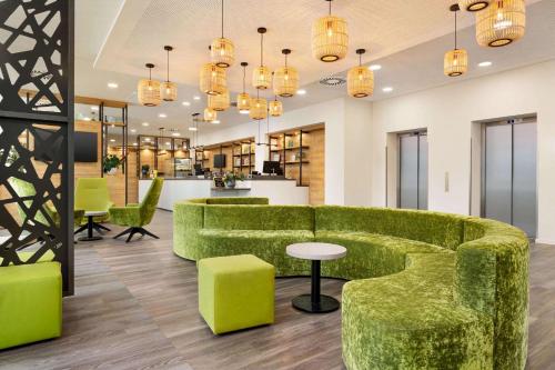a lobby with green furniture and tables and chairs at Super 8 by Wyndham Chemnitz in Chemnitz