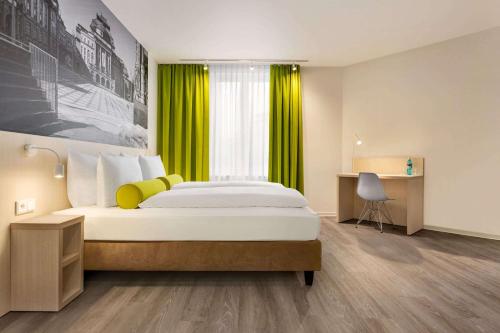 a bedroom with a large bed with a yellow curtain at Super 8 by Wyndham Chemnitz in Chemnitz