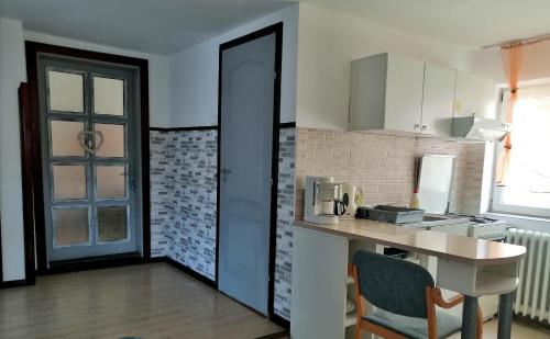 een keuken met een aanrecht en een tafel met stoelen bij Apartament Sarco in Vatra Dornei