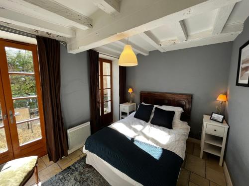 una camera da letto con un letto con pareti blu e una finestra di Charming Cottage in Chateau les Roches gardens a Mont-Saint-Jean