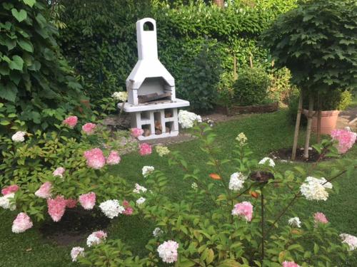 einen Garten mit einem Vogelhaus inmitten von Blumen in der Unterkunft Gästehaus Melz Schwabe in Scharbeutz