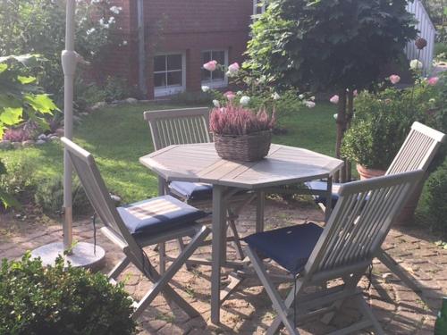 einen Picknicktisch mit zwei Stühlen und einem Blumenkorb in der Unterkunft Gästehaus Melz Schwabe in Scharbeutz