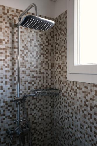 a shower in a bathroom with brown tiles at Casa SavAnna in Torre Lapillo