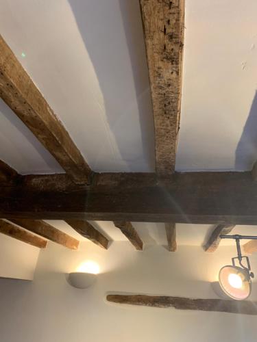 a ceiling with wooden beams and lights on it at Stoop Cottage - in the heart of Quorn in Quorndon