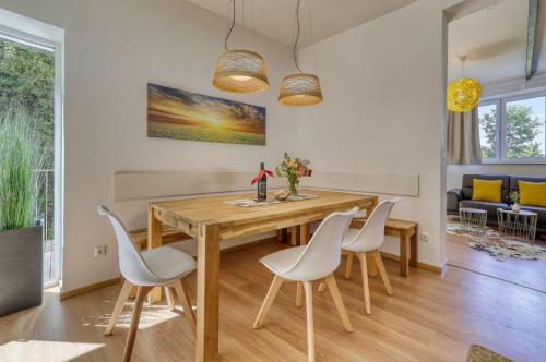 德拉塞斯里德的住宿－Das Bachhaus，一间带木桌和白色椅子的用餐室