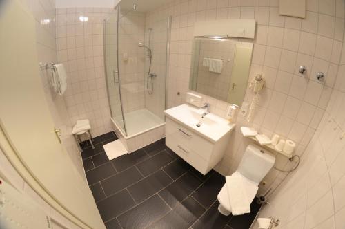 a bathroom with a toilet and a sink and a shower at Hotel Am Markt in Karlsruhe