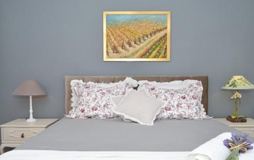 a bedroom with a bed with pillows and a painting on the wall at Bora bora Apartment in Kaštela