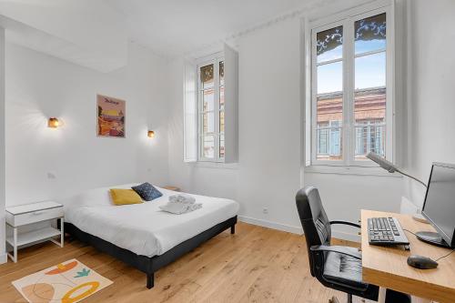 une chambre avec un lit et un bureau avec un ordinateur dans l'établissement LE CODRUS - Charmant appartement dans l'hyper centre toulousain, à Toulouse