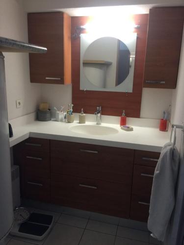 une salle de bain avec un lavabo et un miroir dans l'établissement Appartement spacieux au Cap d'Agde 120 m² avec piscine partagée, au Cap d'Agde