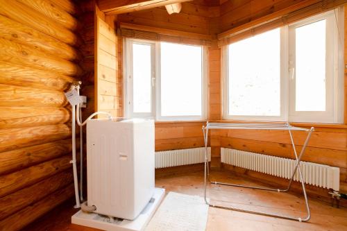 a room with a heater in a wooden room with windows at Lake Toya Hillside House in Lake Toya