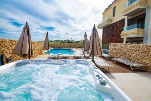 a hot tub on a patio next to a pool at Santa Lucia Boutique Hotel in Santa Luċija