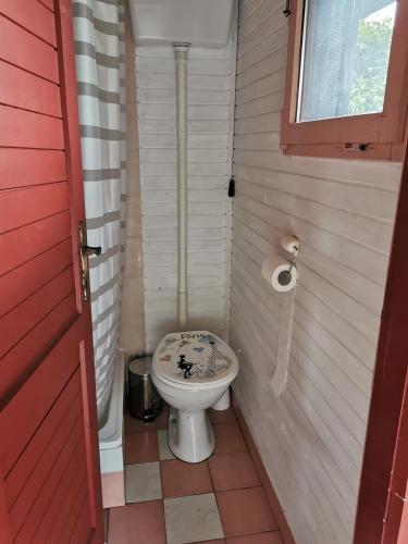 a small bathroom with a toilet and a red door at KOZJANSKA KOČA in Podčetrtek