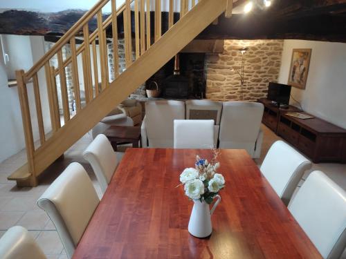 une table en bois avec un vase de fleurs dessus dans l'établissement Petite et grande longères familiale avec jardin - nature & plages, à Limerzel