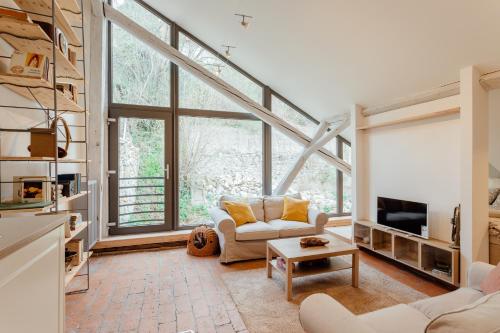 a living room with a large window and a couch at Boutique apartments in Banská Štiavnica
