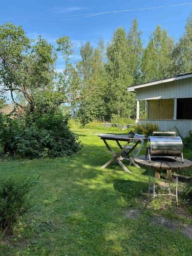 uma mesa de piquenique num quintal ao lado de uma casa em Hus nära Hallstaberget em Solleftea