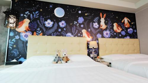 a bedroom with two beds with two stuffed animals on them at Urtrip Hotel in Taipei