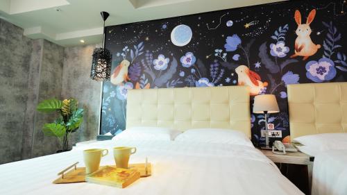 a bedroom with a large white bed with a bunny mural at Urtrip Hotel in Taipei