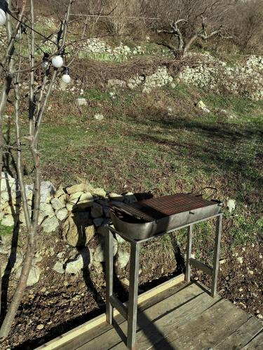 a grill sitting on a wooden platform next to a tree at Horizon Lodge Medurec in Ulcinj