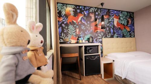 two stuffed rabbits are standing in a bedroom at Urtrip Hotel in Taipei