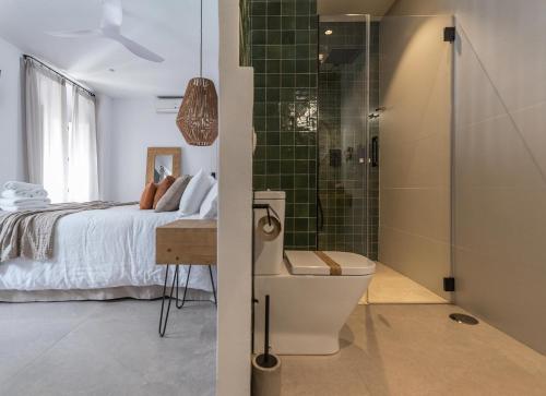 sypialnia z łóżkiem i prysznicem z toaletą w obiekcie Hospedería Boutique by La Judería De Vejer- ADULTS ONLY w mieście Vejer de la Frontera