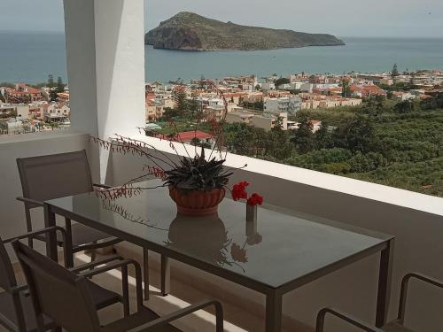 a table with a potted plant on a balcony at Thea Apartment in Agia Marina Nea Kydonias