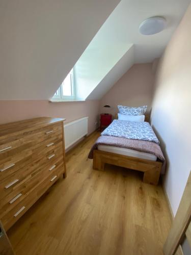 a bedroom with a bed and a dresser in a attic at Schöne drei Raumwohnung. Hell,stilvoll, gemütlich. in Borna
