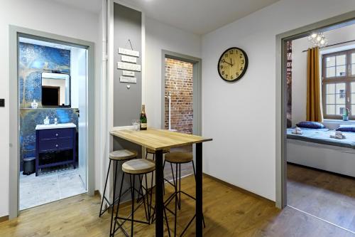 a kitchen with a table and stools in a room at Rynek 3 Old Town in Wrocław