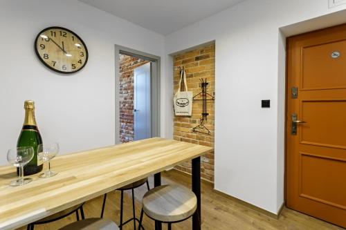 a kitchen with a table and a clock on the wall at Rynek 3 Old Town in Wrocław