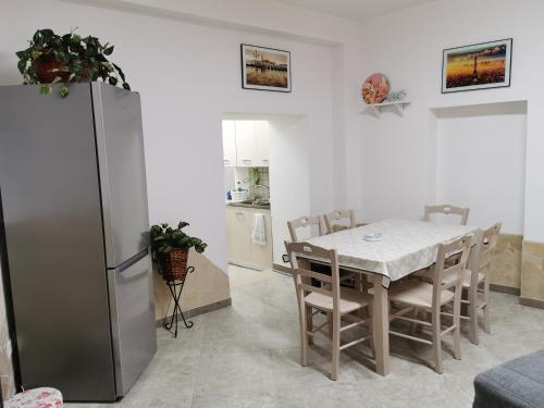 eine Küche und ein Esszimmer mit einem Tisch und einem Kühlschrank in der Unterkunft House Umberto I in Viagrande