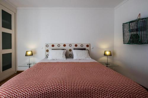 1 dormitorio con 1 cama grande de color rojo y 2 lámparas en Beach Park Apartments, en Luz