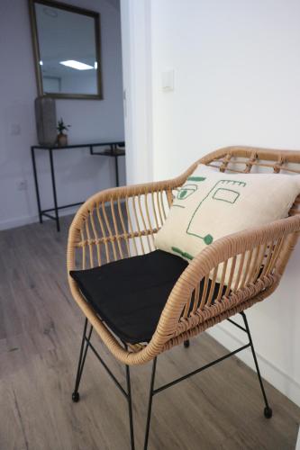 a wicker chair with a pillow on top of it at Casa das Antas in Porto