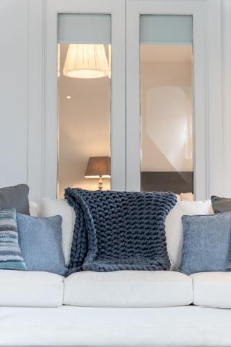 a white couch with blue pillows on it at Bryan Street Apartments in Ballymena
