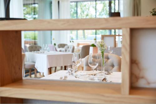 a table with wine glasses and flowers on it at Hotel Rudolf in Brunico