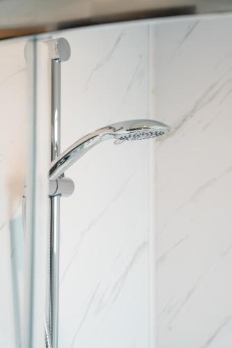 a shower head in front of a window at Bryan Street Apartments in Ballymena