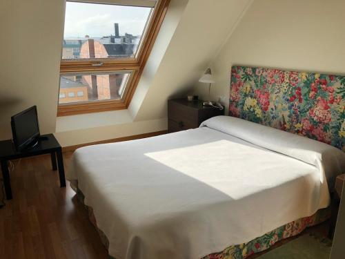 een slaapkamer met een groot bed en een raam bij Apartamento para 6 personas con piscina y paddle in Foz