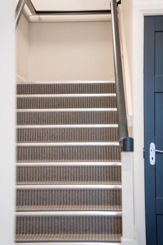 an empty stairs in a building with a blue door at Bryan Street Apartments in Ballymena