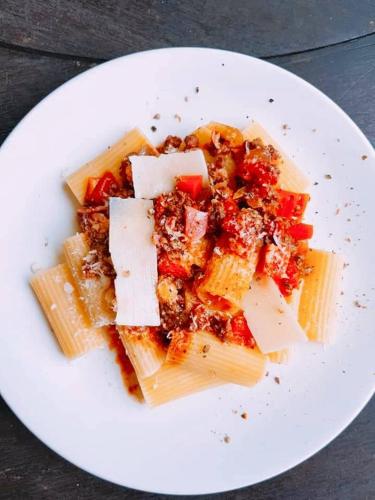 a plate of pasta with cheese and vegetables on a table at Saphli Villa in Chumphon
