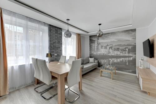 een woonkamer met een tafel en een bank bij Comfort Apartments Old Town Grobla in Gdańsk