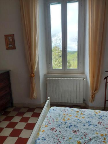 sypialnia z łóżkiem, oknem i podłogą wyłożoną szachownicą w obiekcie Da Nonna Irma Massa Marittima w mieście Massa Marittima