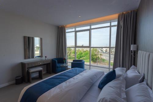 um quarto de hotel com uma cama e uma grande janela em Sweet Light Serviced Apartments em Tabuk