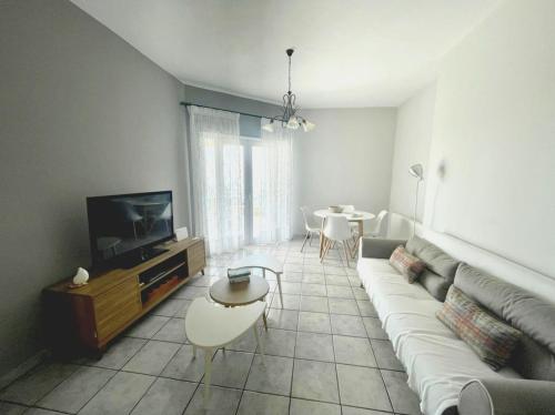 uma sala de estar com um sofá, uma televisão e uma mesa em Villa Panorama em Ligia