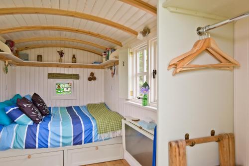 a small bedroom with a bed in a tiny house at Mill Farm Shepherds Hut in Great Driffield